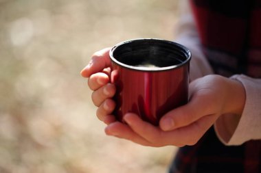 Kız elinde bir kupa limonlu çay tutuyor.