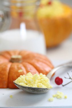 balkabağı arka planında kaşık içinde kabak lapası