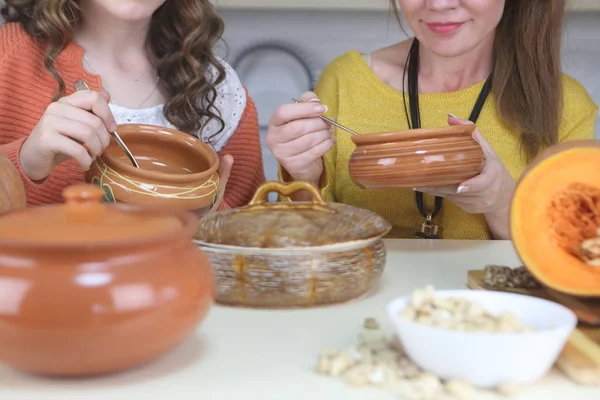 Family eats pumpkin porridge in the kitchen