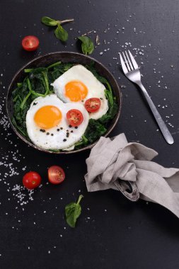 Kızarmış yumurta, ıspanak ve domates.