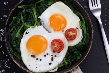 Kızarmış yumurta, ıspanak ve domates.