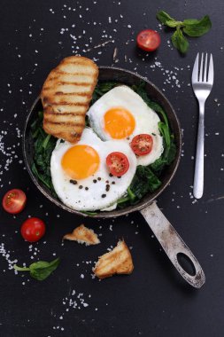 Ispanaklı yumurta, domates ve kızarmış ekmek.