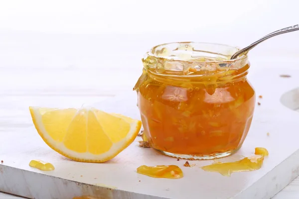 Lepel Een Pot Jam Oranje Jam Een Witte Houten Achtergrond — Stockfoto