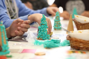 Çocukların elleri kurabiyelerden bir Noel ağacı yapar. Yenilebilir ağaç