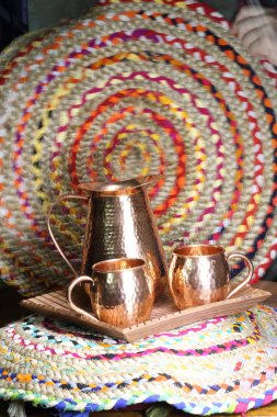 Bakır sürahi ve ahşap tepside iki bardak.