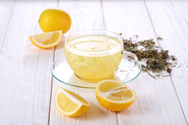 Limonlar ve limonlu içecekler beyaz tahta bir masada. Şeffaf bardakta limon suyu