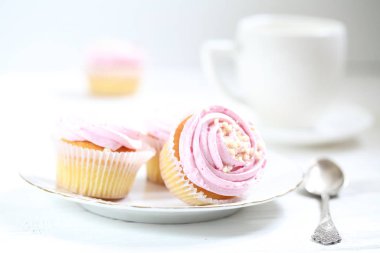 Beyaz arka planda kremalı kekler.