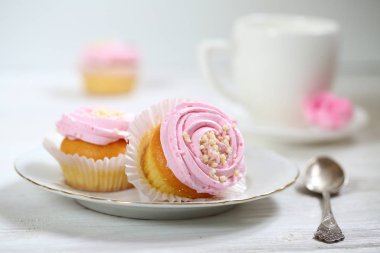 Beyaz arka planda kremalı kekler.