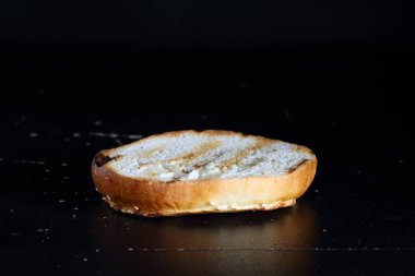 Siyah arka planda hamburger ekmeği. Yarım burgerli çörek.