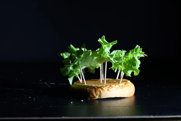 Green lettuce leaves on a black background