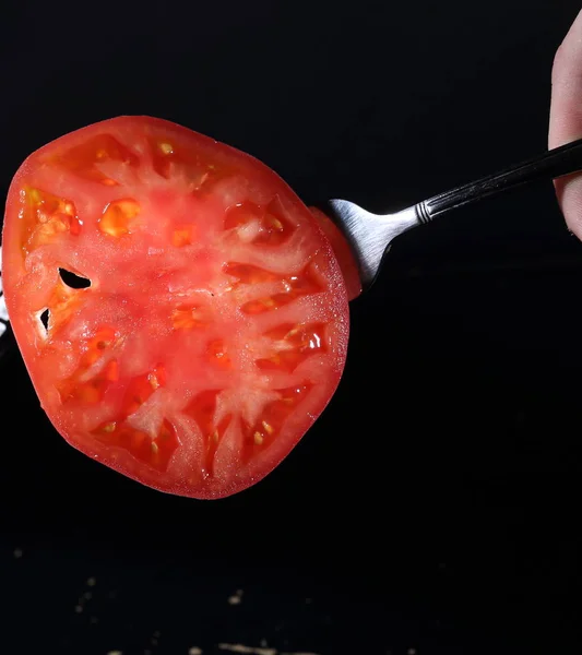 Tomato on a black background. Mug of tomato