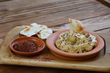 Baharatlı humus ve pide ekmeği. Seramik tabakta humus.