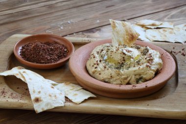 Tahta bir masada seramik tabakta humus.