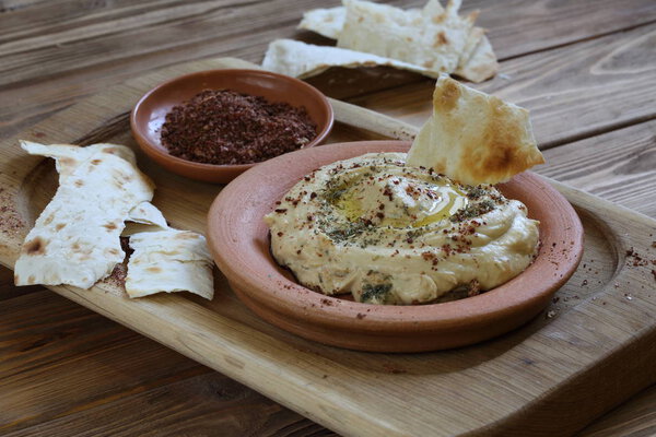 Хумус с приправами и пита-хлебом. Хумус в керамической пластине
