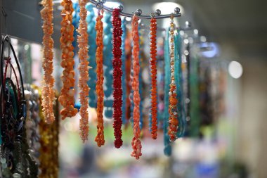 Boncuklar. Mağazadaki tezgahın üzerinde çok renkli boncuklar asılı.