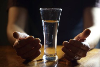 Erkeklerin elleri bir bardak su tutar.