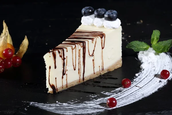 Siyah Arka Planda Yaban Mersinli Naneli Çikolata Soslu Cheesecake — Stok fotoğraf