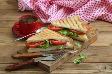 Beyaz arka planda peynirli, domatesli ve jambonlu sandviç.