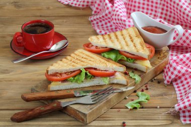 Beyaz arka planda peynirli, domatesli ve jambonlu sandviç.