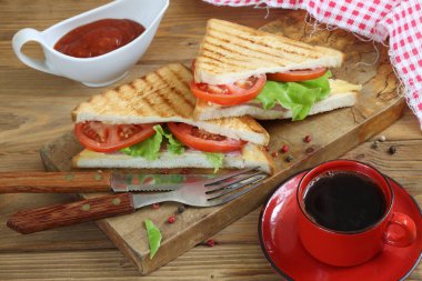 Beyaz arka planda peynirli, domatesli ve jambonlu sandviç.