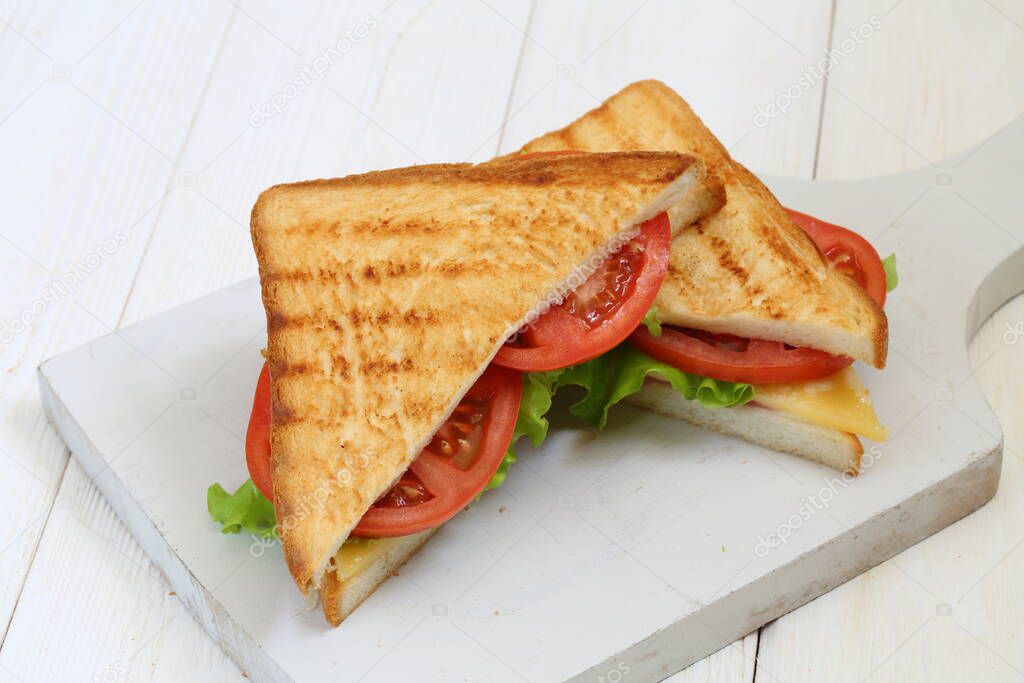 Sandwich with cheese, tomato and ham on a white background