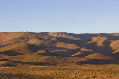 Uzun gölgeler ile Dağları günbatımı çöl.
