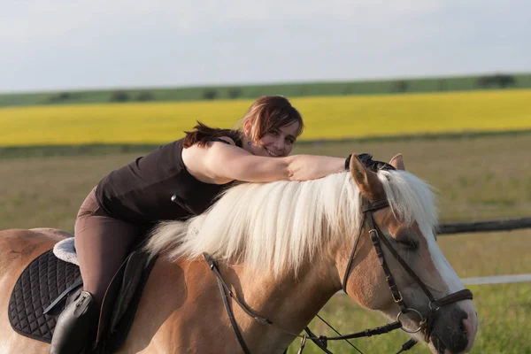 Une jeune femme posant sur un cheval Haflinger — Photo