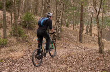Genç adam bir dağ bisikleti throughs ormanda sürme.