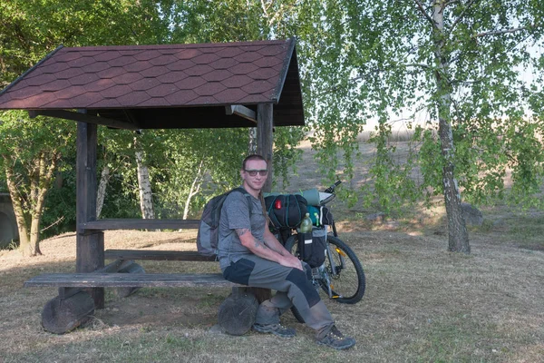 Biker assis sur un banc sous gazepo — Photo