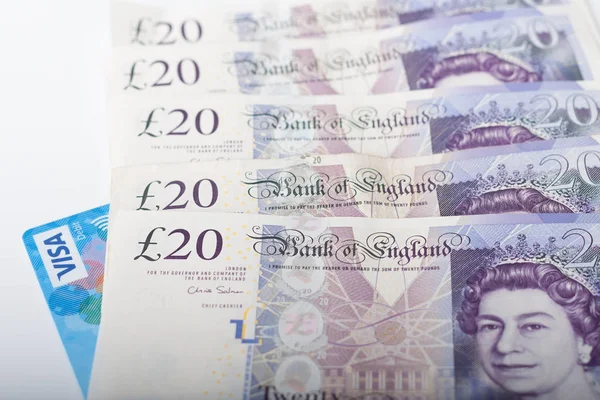 VISA kartı ve beyaz arka plan üzerinde İngiliz Sterlini