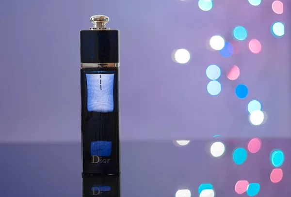 Butelkę perfum na czarny akrylowy arkusz, światła na tle. — Zdjęcie stockowe