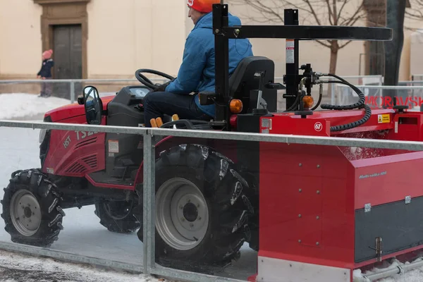 Man in trekker reinigt kunstmatige ijsbaan — Stockfoto