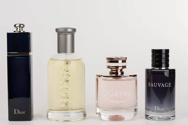 Quatro garrafas da fragrância para mulheres e para homens em bac branco — Fotografia de Stock