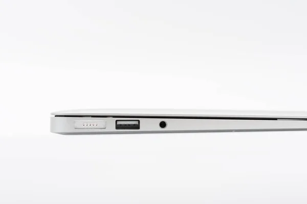 Bagian dari laptop baru modern tertutup dengan port pada latar belakang putih — Stok Foto