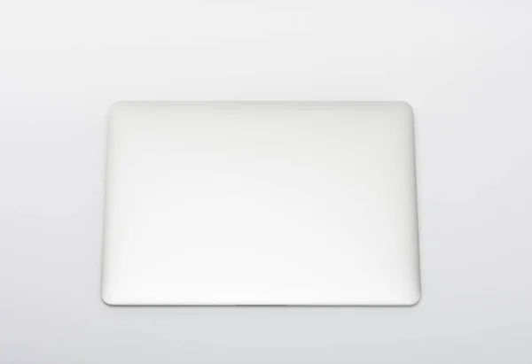 Fechado moderno, novo laptop no fundo branco, vista superior . — Fotografia de Stock