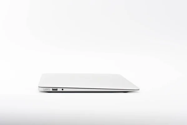 Closed  modern, new laptop on white background, side view. — Stock Photo, Image