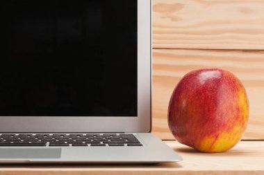 Ahşap arka plan üzerinde apple ile açık dizüstü
