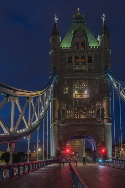 Tower Bridge in the night is opening for cruise and is closing for cars traffic , London, England.