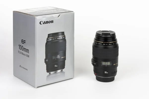 Caixa e lente Canon EF 100 mm f 2,8 sobre fundo branco — Fotografia de Stock