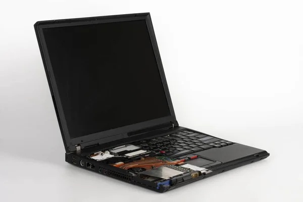 Old laptop, removed half of keyboard on white background, visible orange cpu fan with heat sink  . — стоковое фото