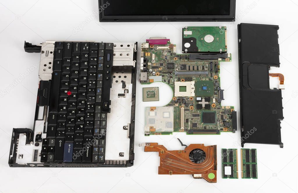 Disassembled laptop, basic components of notebook, screen, keyboard, processor, motherboard, internal  hard disk drive, CPU fan.