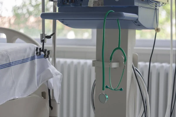 Green stethoscope hanging on medical ventilator in ICU in hospital, a place where can be treated patients with pneumonia caused by coronavirus covid-19.