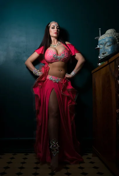 Sexy slim woman, belly dancer in pink costume with crystals. Dark background — Stok fotoğraf
