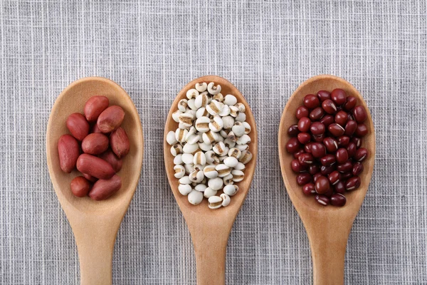 Many types of beans in wooden spoon.