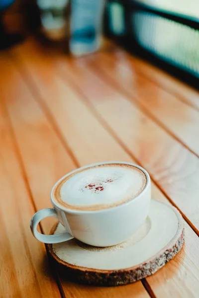 Tasse Kaffee auf dem hölzernen Schreibtisch im Café Café mit Vintage-Farbton Filter Hintergrund — Stockfoto