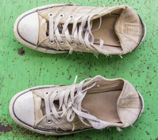 Пара старых кроссовок на зеленом фоне — стоковое фото