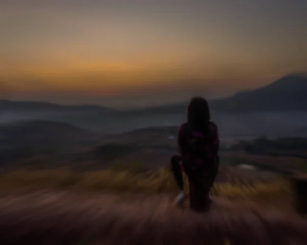 Mujer sentarse ver a la salida del sol — Foto de Stock