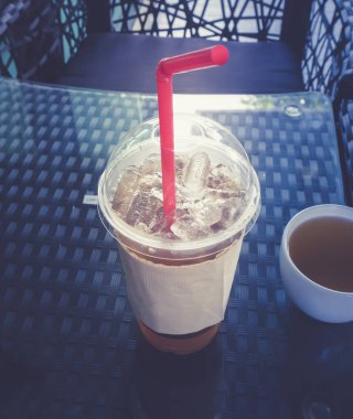 Buz plastik cam ve kırmızı tüp masada