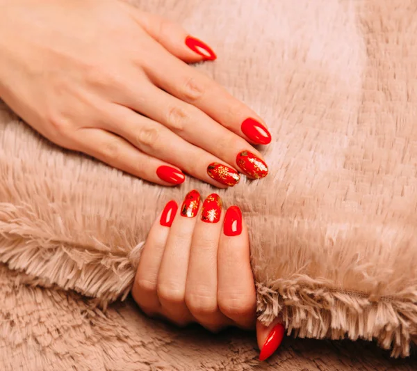 Vrouwelijke handen met rode manicure op zacht textiel. — Stockfoto