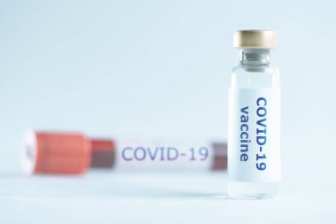 Coronavirus kan örneğiyle kovan 19 aşısı test tüpünün önünde..